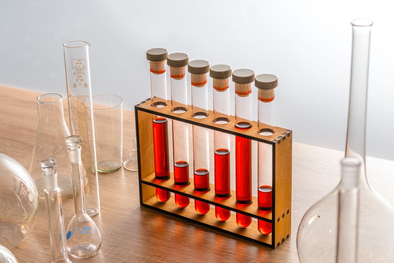 Glass test tubes in a wooden rack on a laboratory bench